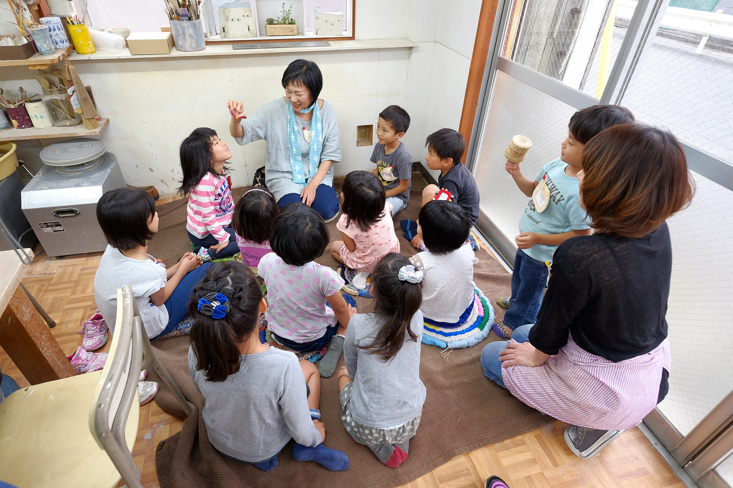 子ども陶芸てこねりのひとコマ。坂野ちえさんの手遊びから始まる。 
