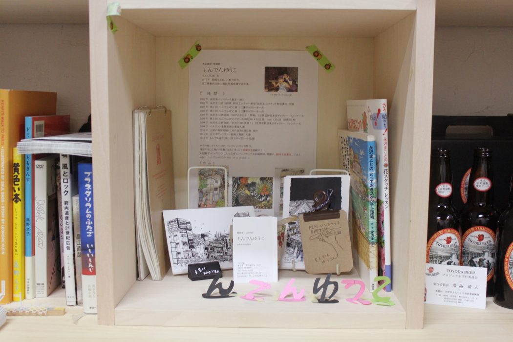 もんでんさんのプロフィールBOX。中にはポストカード（１枚100円）やもんでんさんと関わりのある永沢氏の本が。